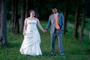 Asheville painting contractors capture the beautiful moment of a bride and groom holding hands in a serene wooded area.