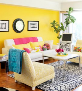 A living room with a vibrant yellow wall exquisitely enhanced with an Asheville painting.