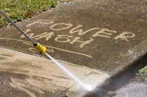 An Asheville Painting Company employee power washing a sidewalk.